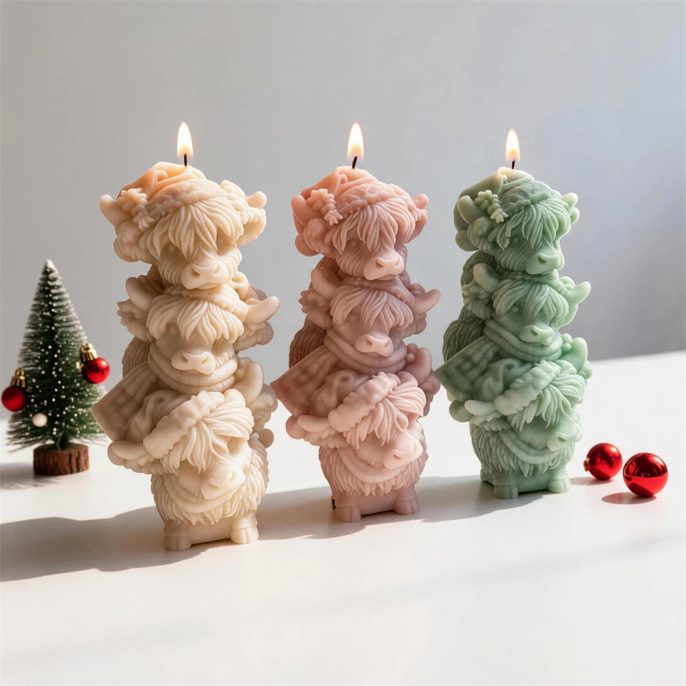 Whimsical tower of three Highland cattle figures made as a candle