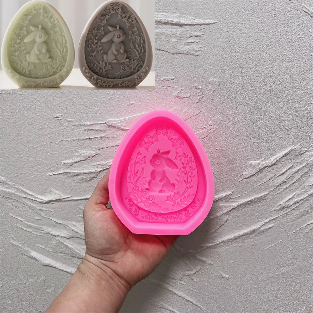 Pink silicone mold with bunny design held by a hand against a gray background