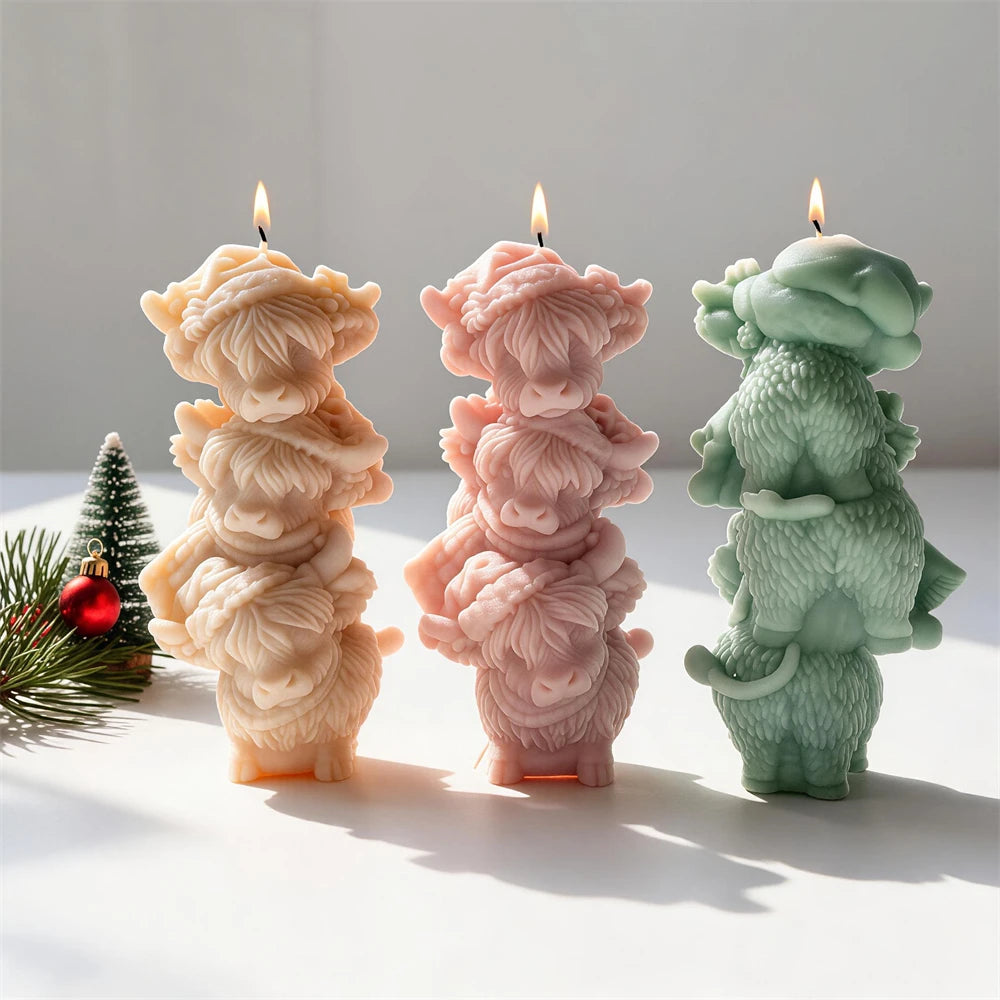Whimsical tower of three Highland cattle figures made as a candle