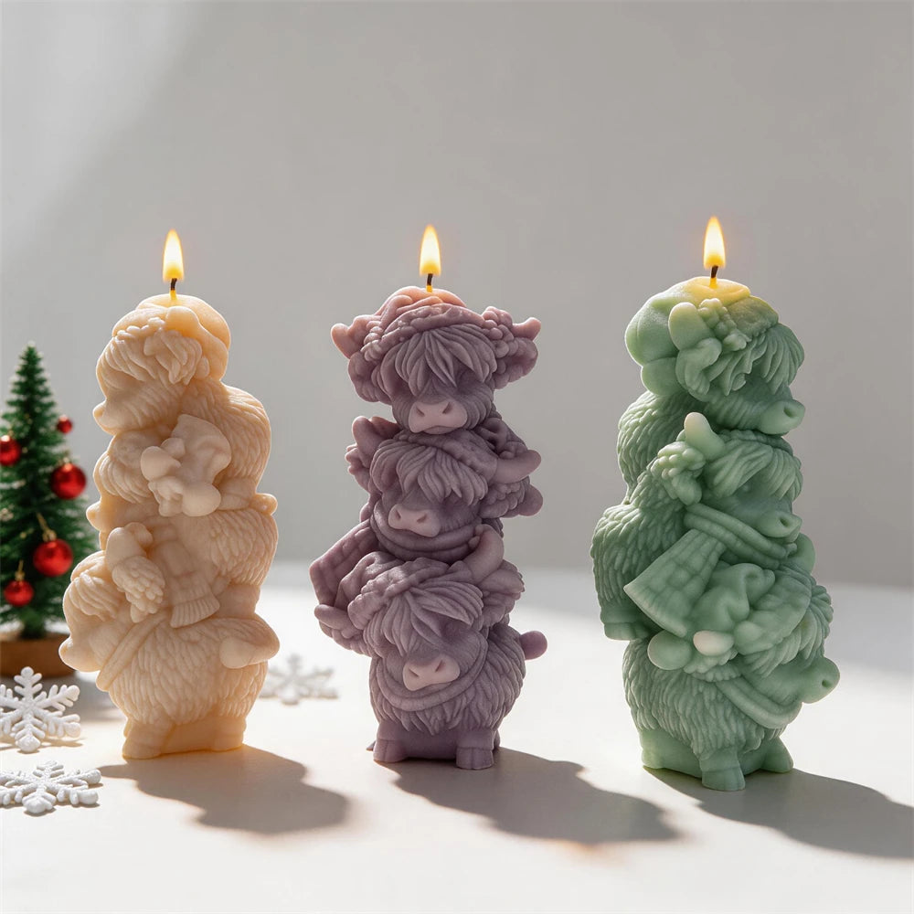 Three stacked Highland cow candles with shaggy fur and small horns