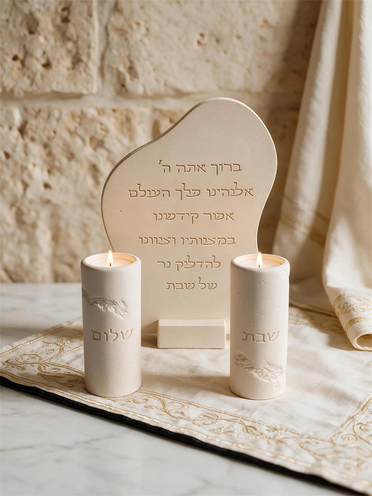 Hebrew candle lighting blessing plaque displayed beside Shabbat candles