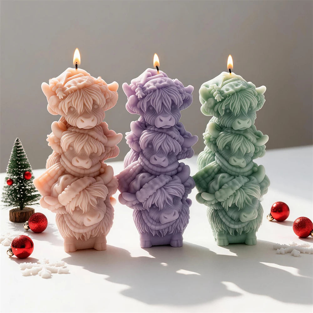 Three stacked Highland cow candles with shaggy fur and small horns