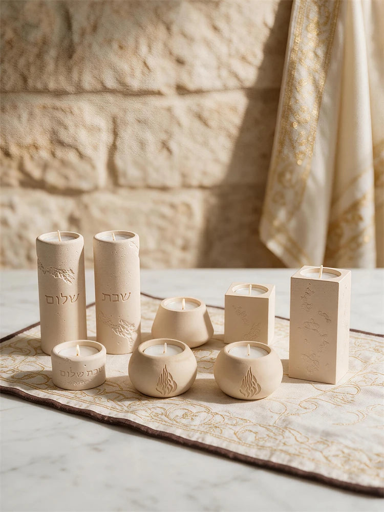 Seven Judaica candle holder designs including Hebrew, flame and geometric styles