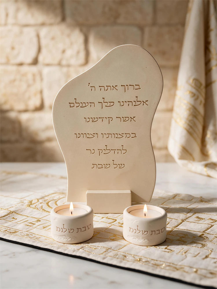 Hebrew candle lighting blessing plaque displayed beside Shabbat candles