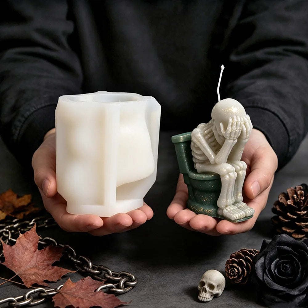 Skeleton sitting on toilet candle with hands covering its face