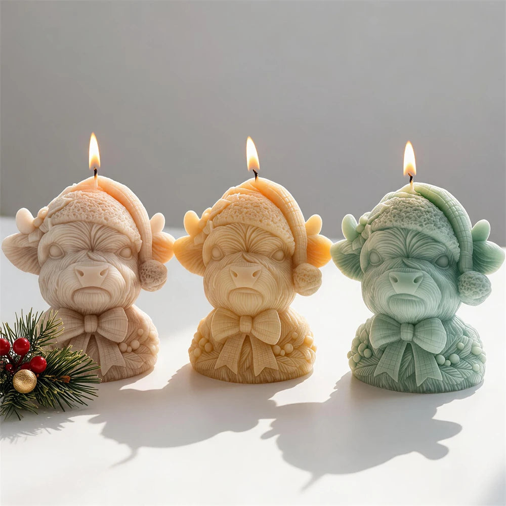 Christmas Highland cow candles wearing knitted Santa hats and ribbon bows